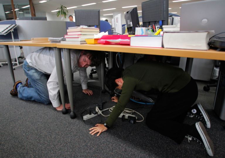 The Shock, Part 1. ”How do you express the shock of an earthquake in a still image? Itsuo Inouye of the Associated Press Tokyo bureau photographed two of his fellow journalists taking shelter under a table as the world shook.” Photo by Itsuo Inouye/AP, “Big Picture”, Boston Globe