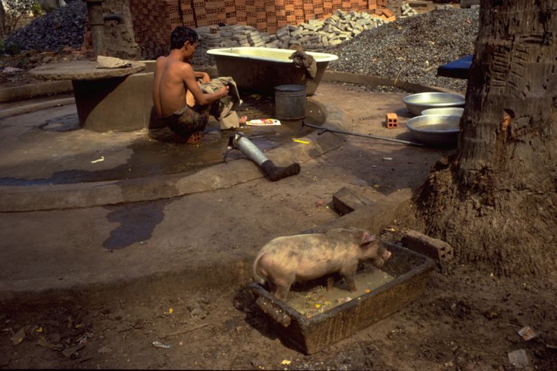Behind Kampong Chhnang's only restaurant at the time, an old soldier performs his ablutions. In 1992 Cambodia still had 9 million landmines. Death and amputation were daily events. © Tim Page