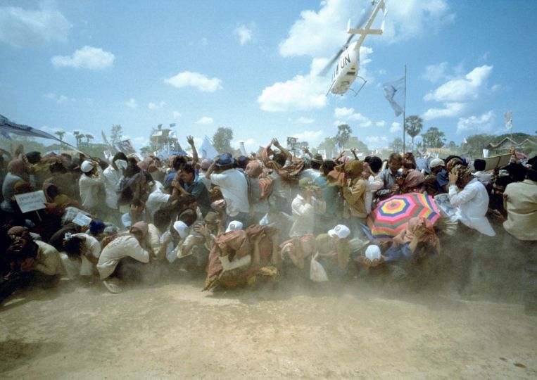 During the UNTAC peace process in Cambodia, the helicopter bearing FUNCINPEC leader Prince Ranaridith Norodom leaves a football field in Prey Veng after campaigning for the upcoming elections. May 1993 (From the book 'Mid Term Report') © Tim Page