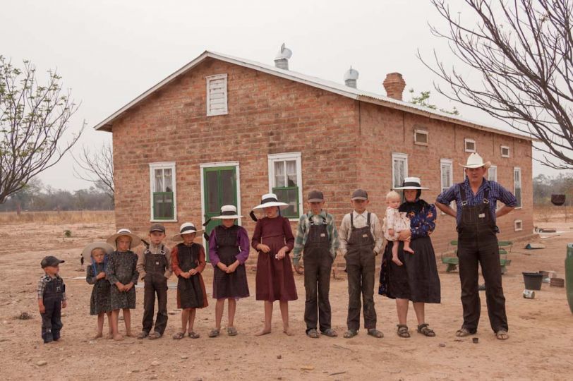 Bolivia. Durango colony. Mennonite family in front of their house (2006). From right to left: Gerhard Klassen (36), Anna Bren (35) with baby Sarah (1), Heinrich (13), Peter (12), Eva (11), Catarina (9), Anna (8), Gerhard (6), Elisabet (5), Elena (3) and Jacob (2). © Jordi Busque