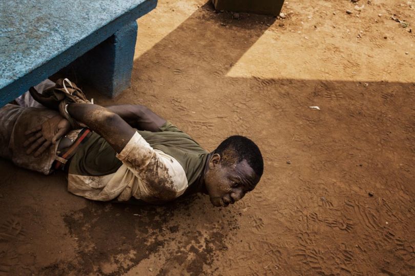 Bangui. A man arrested by MISCA (Mission Internationale de Soutien a la Centrafrique Sous Conduite Africaine) soldiers lies on the ground with his wrists tied. He was found with a grenade in a pocket. © William Daniels