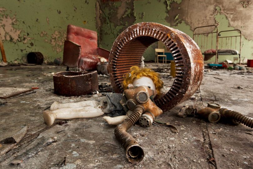 [Pripyat, Ukraine, 2011] Chairs, children's toys and gas masks offer a surrealist still life in an abandoned kindergarten classroom. After the accident, all useful items were taken; now tourism is leaving its own mark. Less and less do buildings bear witness to the hasty departure of their former residents; instead, there are signs of the visitors' need to simplify the message. Most noticeably, dolls like this one, carefully arranged next to a gas mask, have become the standard motif. / [Pripiat, Ukraine, 2011] Des chaises, des jouets et des masques à gaz comme nature morte surréaliste dans une pièce d'un jardin d'enfants. En raison des nombreux pillages après l'accident, les immeubles content de moins en moins de la vie avant la catastrophe. Une poupée abandonnée couchée à côté d'un masque à gaz devient le motif standard de prédilection. © Gerd Ludwig / National Geographic Creative / National Geographic Magazinen
