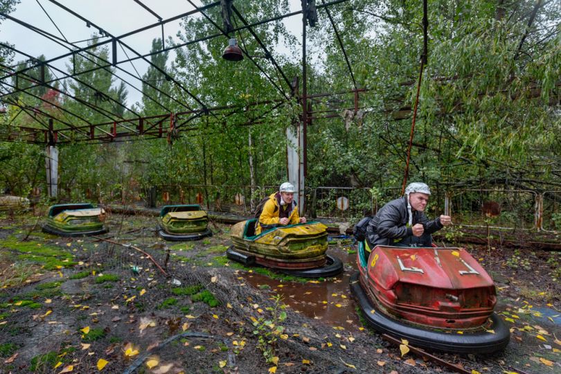 [Pripyat, Ukraine, 2013] Finnish sightseers pose in bumper cars in an amusement park that was being readied for the annual May Day celebrations, days before the reactor blew up on April 26, 1986. © Gerd Ludwig / National Geographic Creative / National Geographic Magazinen