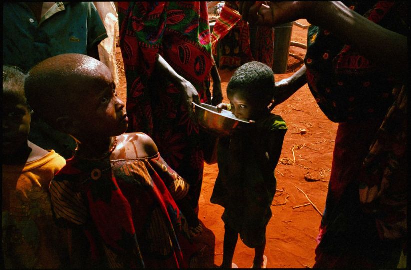 La sécheresse en Afrique - Wargaddud, NE Kenya, Mars 2006. Un camion apporte de l'eau à la citerne du village deux fois par semaine. Les mères donnent de l'eau frau00eeche à leurs enfants. Plus de 4 millions de gens sont touchés par la pire sécheresse de mémoire d'homme, qui affecte la région. Le bétail est décimé et tout un style de vie menacé. Photo extraite d'un reportage réalisé avec le soutient du World Food Program, exposée à Visa pour l'Image en 2006 : u201cDrought in the Horn of Africau201d. © Bruno Stevens / Cosmosn