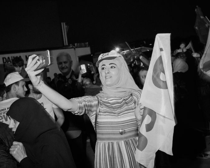 A woman, attending to referendum celebrations, takes a selfie © Cihan Demiral