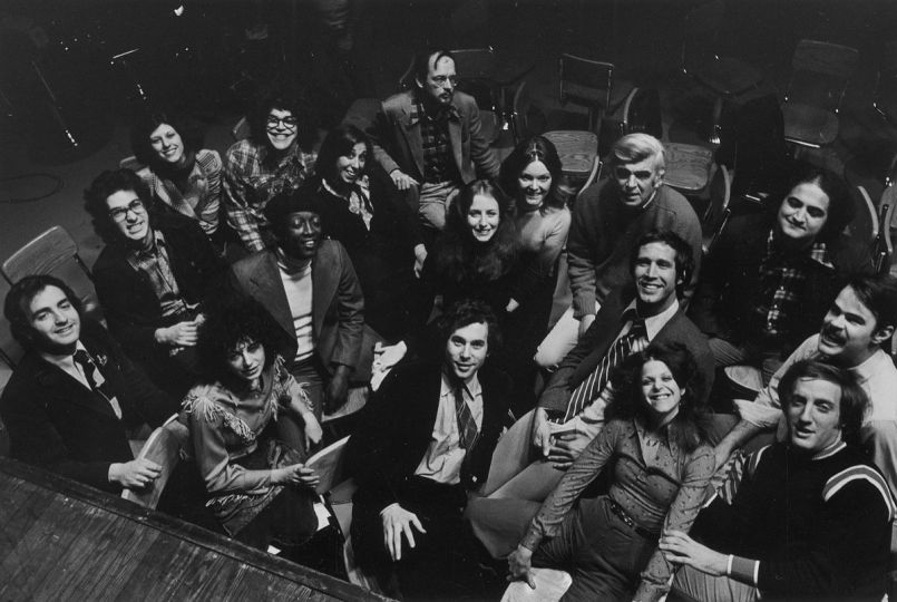 The original cast of Saturday Night Live, c. 1976; those pictured include writers Anne Beatts and Al Franken (upper left); in the center and right, cast members Garrett Morris, Laraine Newman, Jane Curtin, and John Belushi, with producer Lorne Michaels seated between Curtin and Belushi; and at the lower right, Gilda Radner, with Chevy Chase behind her and Dan Aykroyd on his left. © 2017 Duane Michals / Courtesy Thames & Hudson