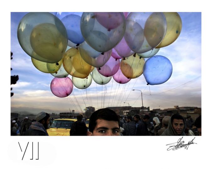 John Stanmeyer, Colorful balloons with a traveling vendor in sharp contrast with the dust and ruined city of Kabul on November 18, 2001. © VII Agency