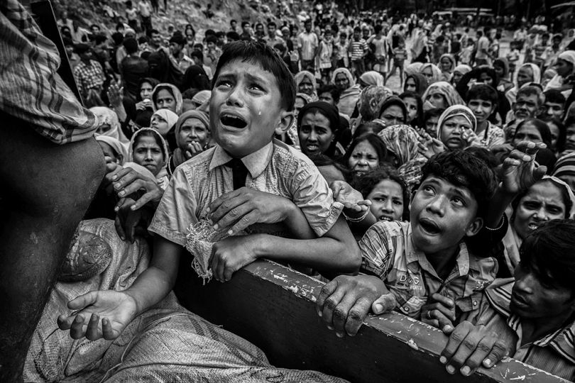 Balukhali refugee camp, Cox's Bazar, Bangladesh, September 20, 2017. A desperate Rohingya boy clambering onto the truck of a local NGO distributing urgent food supplies to newly arrived refugees. Camp de réfugiés de Balukhali, Cox’s Bazar, Bangladesh, 20 septembre 2017. Un garçon rohingya désespéré s’accroche au camion d’une ONG locale qui distribue des colis alimentaires d’urgence aux réfugiés récemment arrivés. © Kevin Frayer / Getty Images