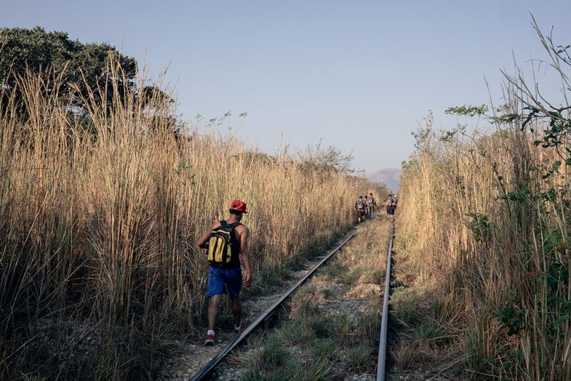 3-Un migrant marche sur le chemin de fer qui relie la ville d' Arriaga (Chiapas) à Chahuites (Oaxaca). Cette route est connue par les migrants comme un passage où les attaques à main armé son très fréquentes. Sur le chemin la plupart des migrants se font volé leurs sac à dos et leurs chaussures. 07/02/2017 Arriaga, Chiapas, Mexique. - Southern Border © Jeoffrey Guillemard