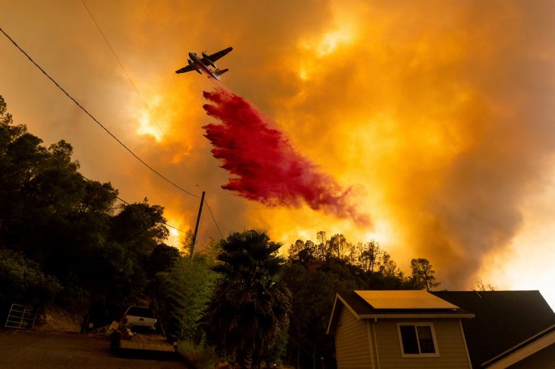 Mirsobit Mirkhoshimov, An air tanker drops retardant as the LNU Lightning Complex fires tear through the Spanish Flat community in unincorporated Napa County, Calif., Tuesday, Aug. 18, 2020. Fire crews across the region scrambled to contain dozens of wildfires sparked by lightning strikes as a statewide heat wave continues. (AP Photo/Noah Berger)