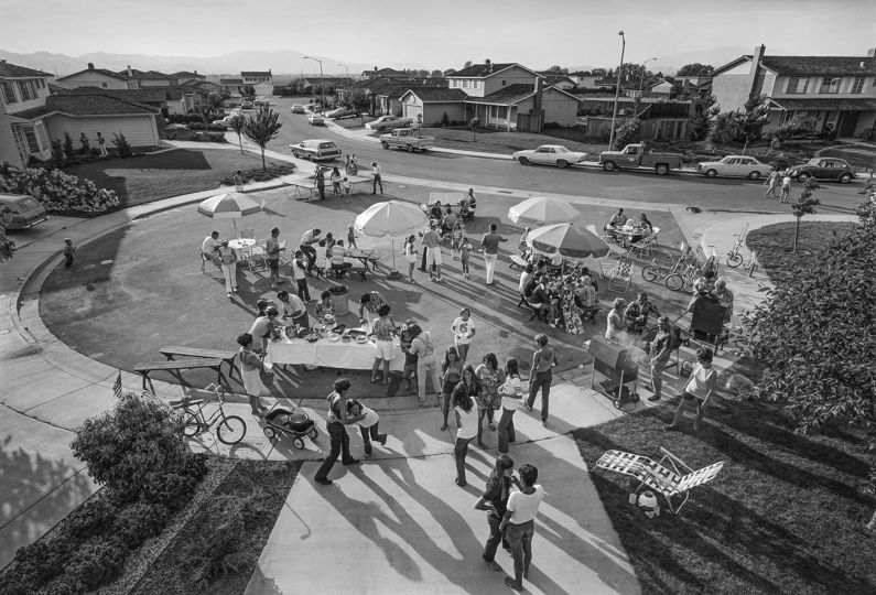 This is our second annual Fourth of July block party. This year thirty-three families came for beer, barbequed chicken, corn on the cob, potato salad, green salad, macaroni salad, and watermelon. After eating and drinking we staged our parade and fireworks. © Bill Owens - Courtesy True North Editions / Scott Nichols Gallery