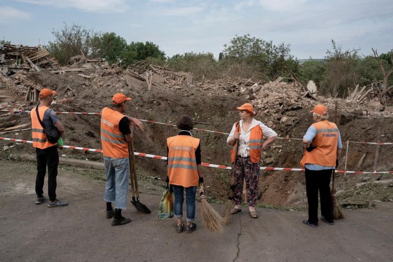 Des gens prennent une pause après avoir nettoyé le principal des déchets laissés sur la route après une frappe entre 2h et 3h du matin, à Droujkivka, Ukraine, le 5 juin 2022. People take a break after clearing the main road of rubbish left behind after a strike between 2 a.m. and 3 a.m., in Druzhkivka, Ukraine, on 5 June 2022. © Adrienne Surprenant/MYOP Ukraine, Droujkivka, le 5 juin 2022. Pause après avoir nettoyé la majorité des déchets laissés sur la route après une frappe nocturne. Reportage réalisé en commande pour Libération