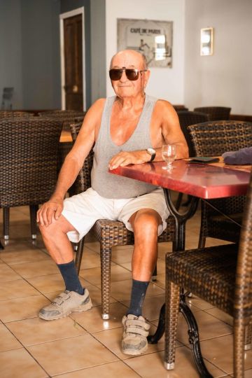 Marius, a regular at the Bar des Sports in Ansouis (Vaucluse, France), seated at his table, on July 26, 2019. Marius, habitué du Bar des Sports d’Ansouis (Vaucluse, France), assis à sa table, le 26 juillet 2019.