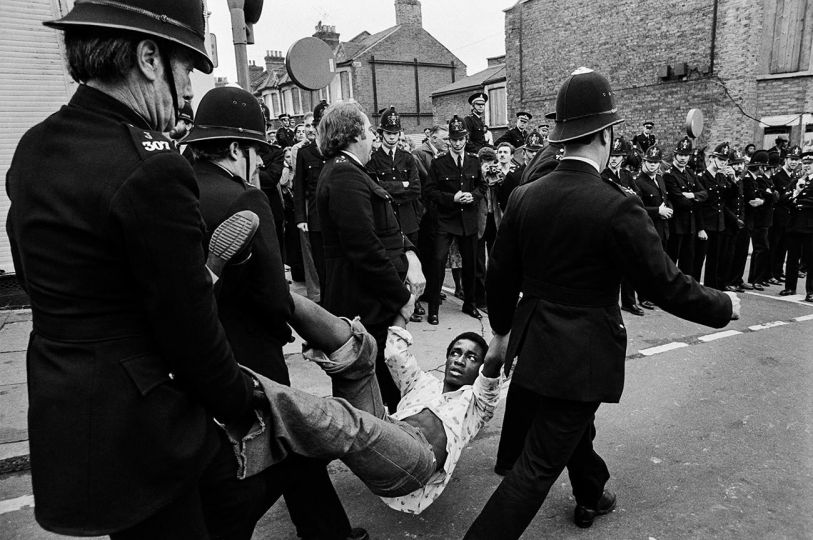 UK - London -The Battle for Lewisham. 13th Aug 1977. Police lead racist and fascist National Front marchers through the streets of Lewisham, into a crowd of anti racists protestors resulting in a delay of violence. The resulting riot broughtthe poice ib riot gear for the first time in mainland Britain. © Mark Abrahams - Courtesy of Bluecoat Press