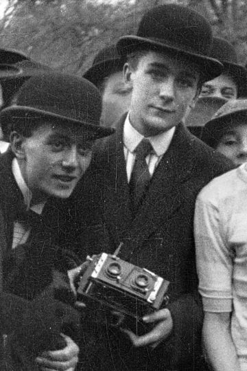Jacques Henri Lartigue, à l’âge de 18 ans, tenant son appareil photo stéréoscopique 6x13cm Nettel. A gauche : son grand frère Zissou. Détail d’un film 35mm Gaumont Actualités. Prix Roosevelt, Racing Club, Bois de Boulogne, 27 octobre 1912